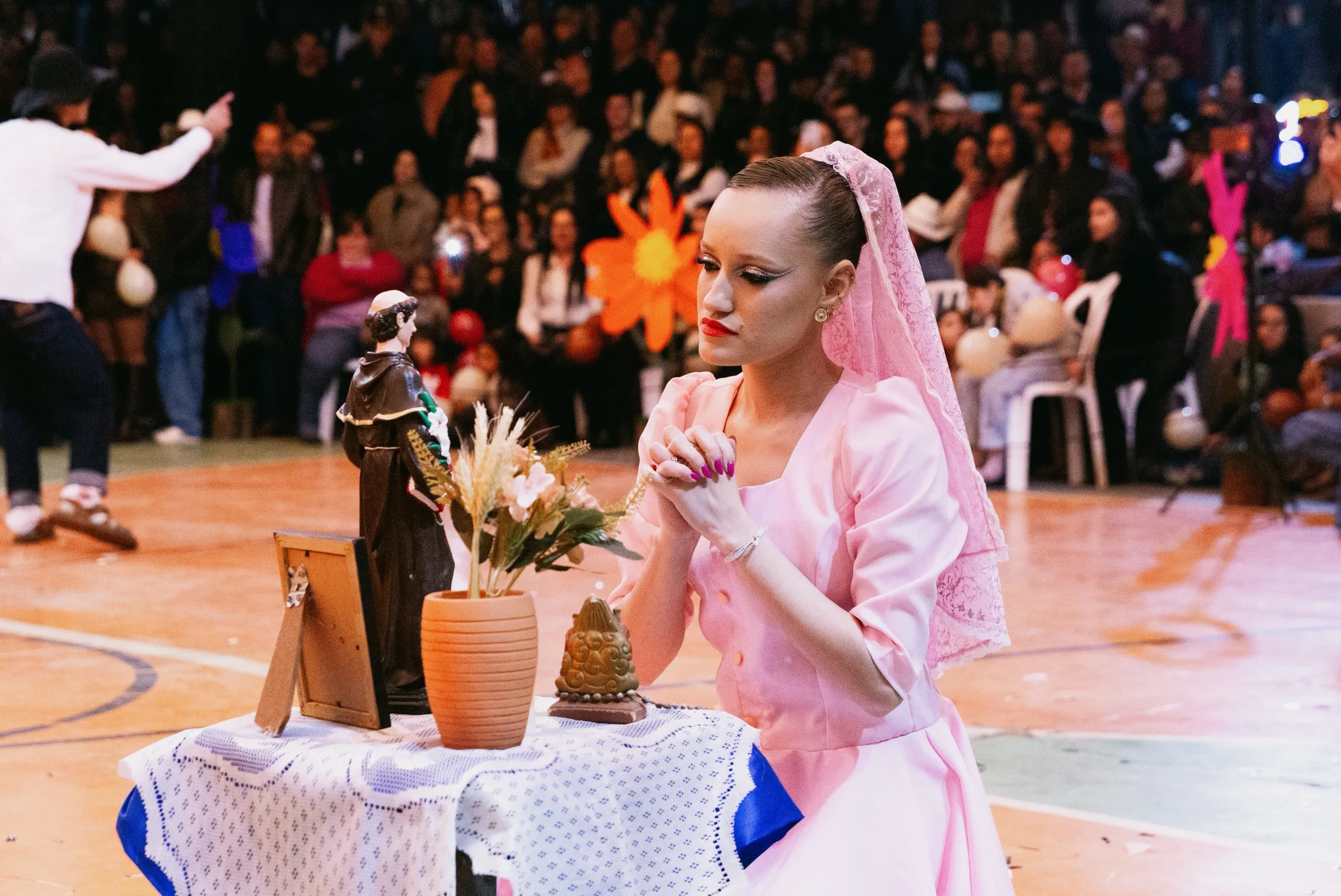 Dançarina de vestido rosa durante apresentação junina.