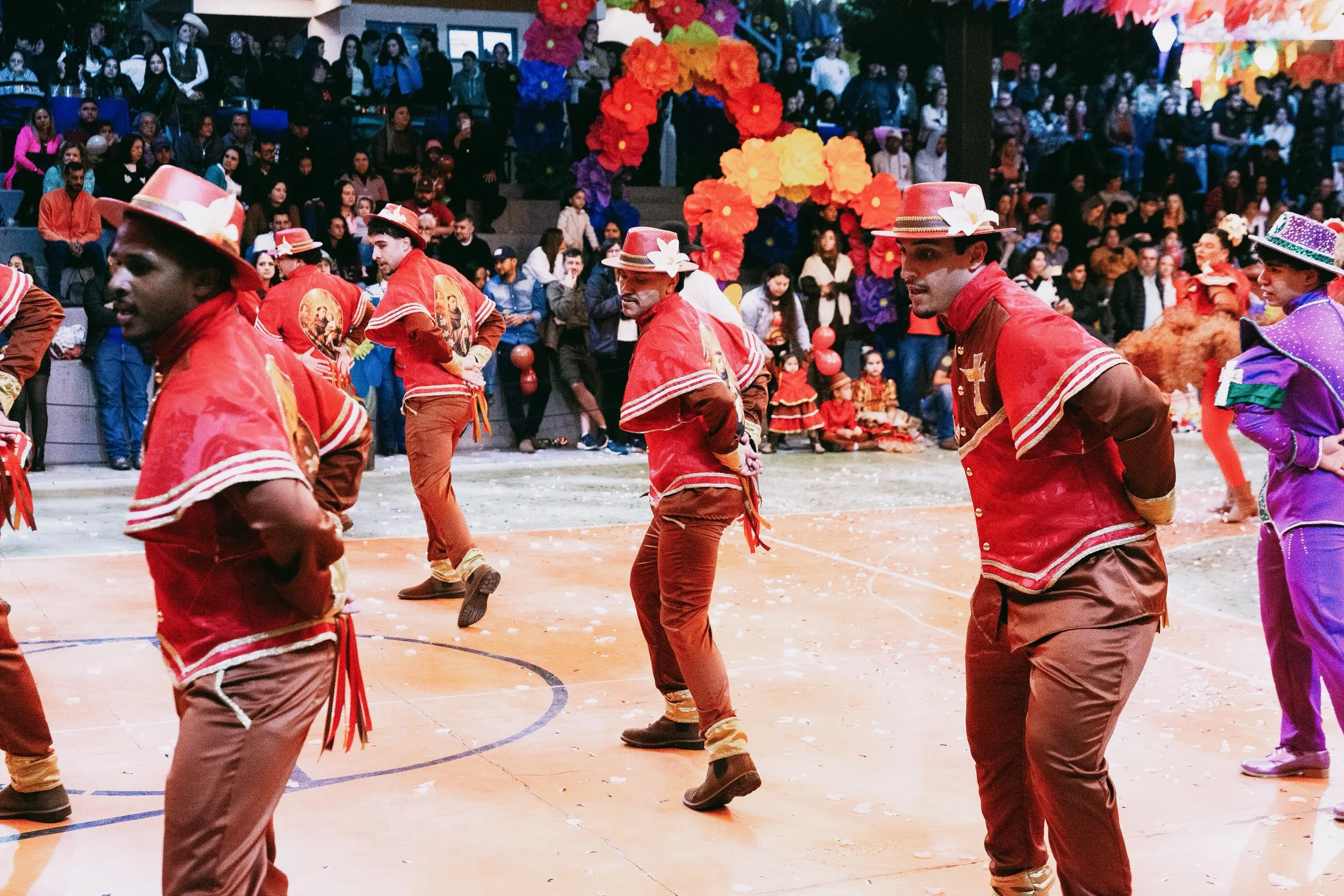 Grupo de dançarinos com roupas vermelhas e chapéus.