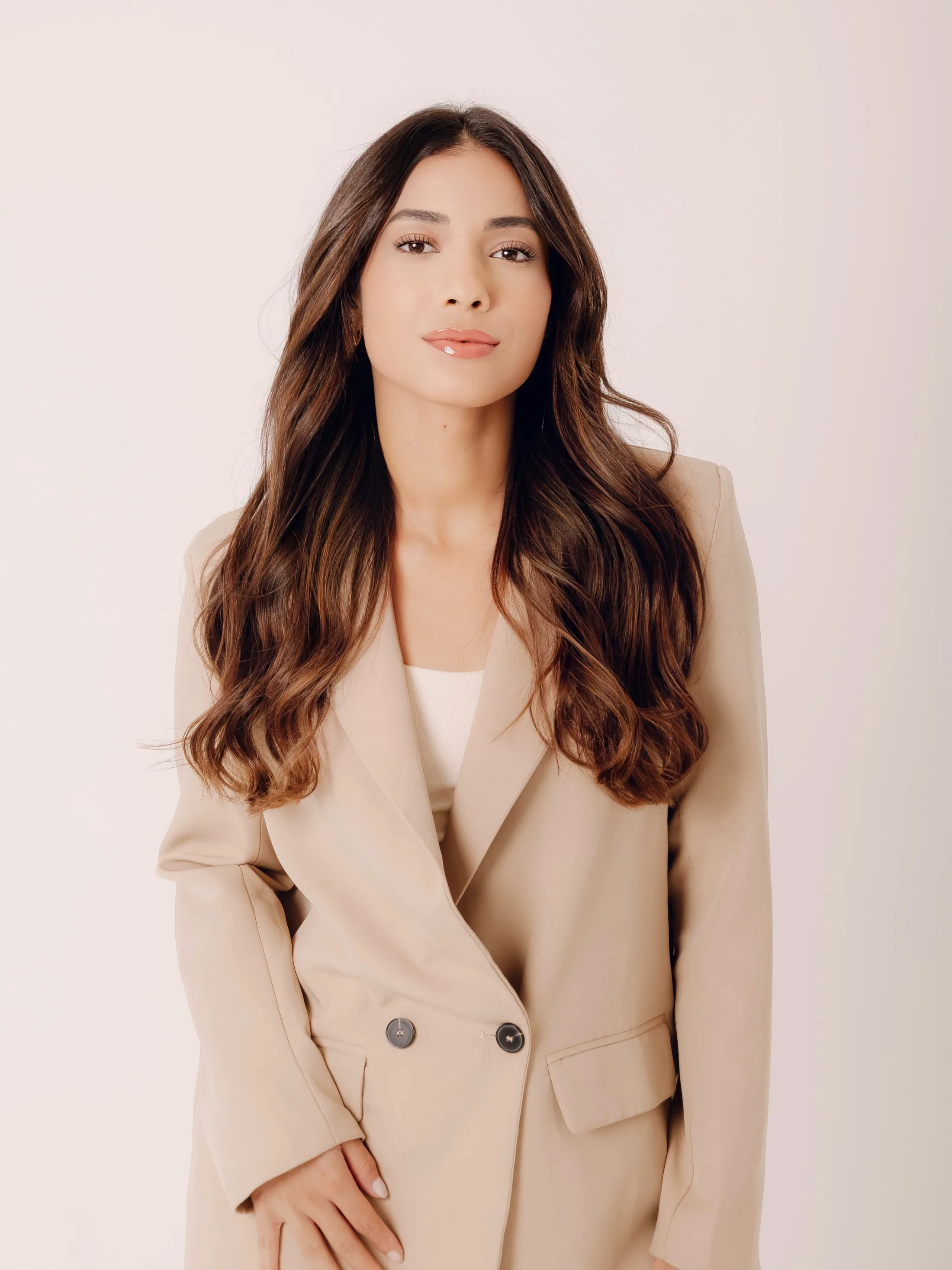 Retrato frontal de mulher com blazer bege.