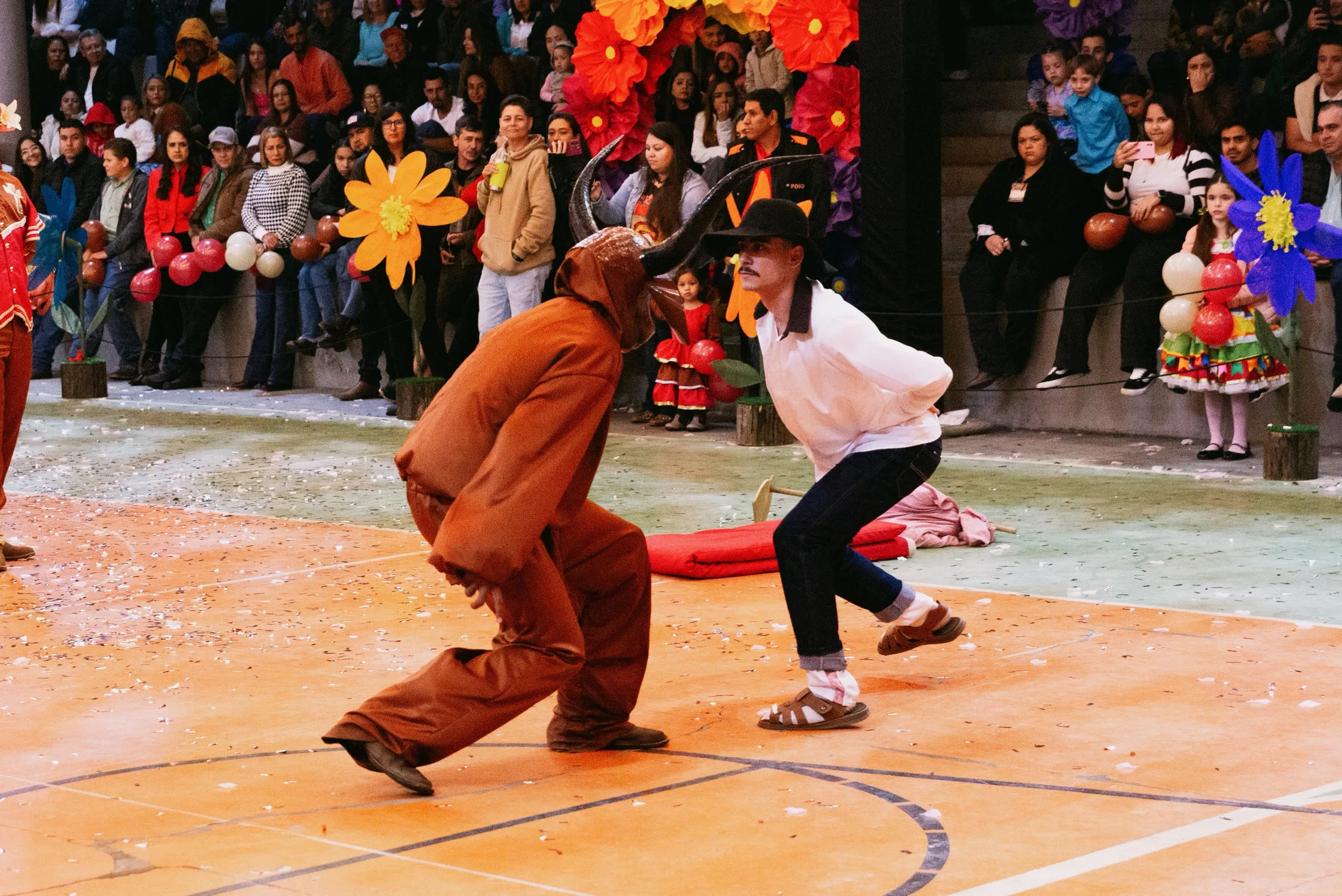Casal dançando no centro de uma apresentação junina.