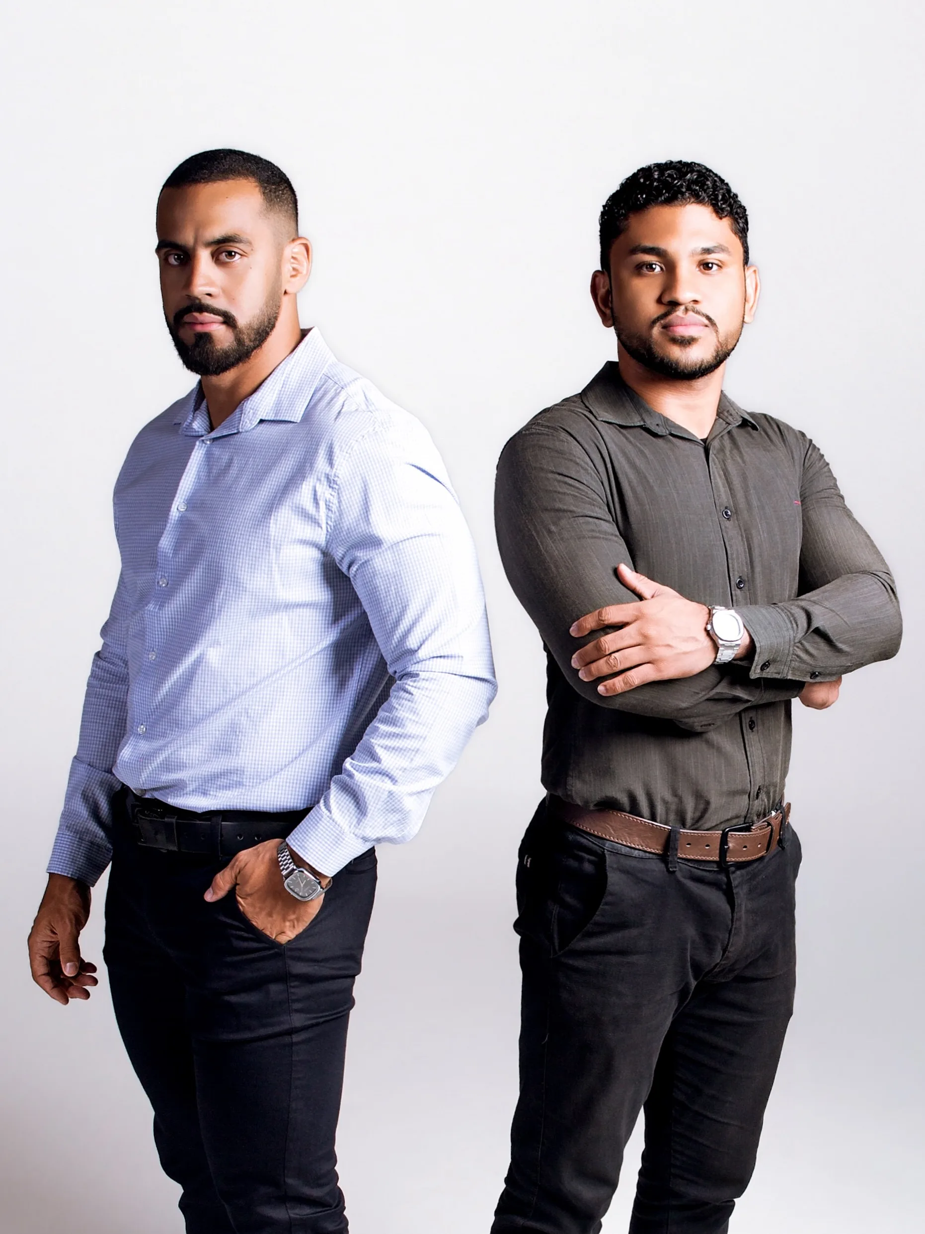 Dupla de profissionais em pé em fundo cinza.